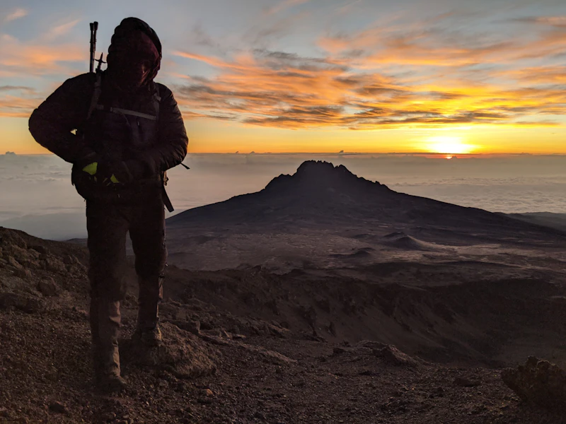 Hiker on a volcanic ridge at sunrise — Day 9 of the 10-Day Tanzania Wildebeest Migration Safari